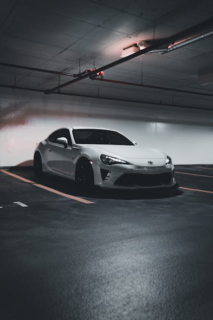 Luxury Cars - A sleek white sports car parked in a dimly lit u #17245056