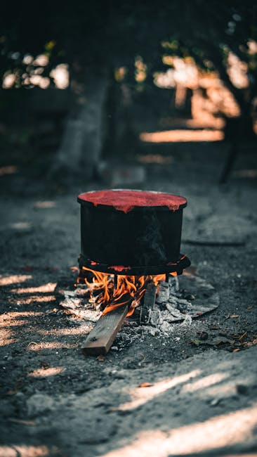 Food Aesthetics - A large black pot heats over an open fire outdoo #34567243