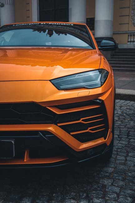 Luxury Cars - Close-up of an orange Lamborghini SUV parked on  #9831581